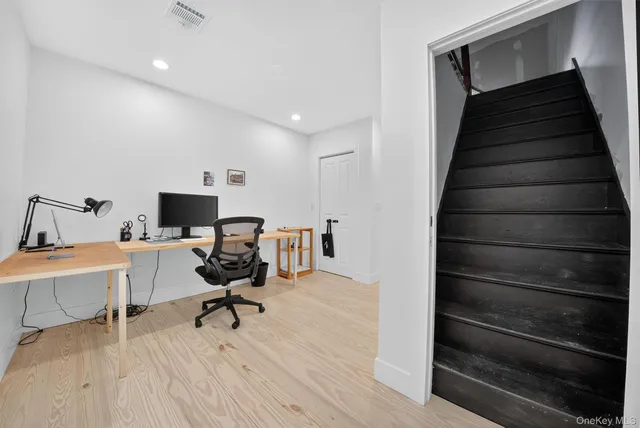 a view of a workspace with furniture and a window