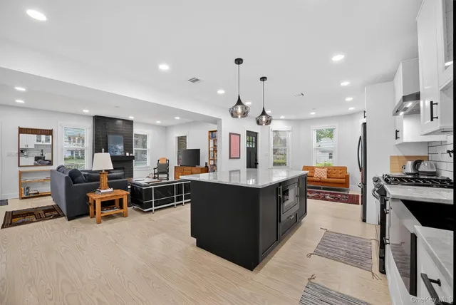 a large kitchen with stainless steel appliances and a view of living room