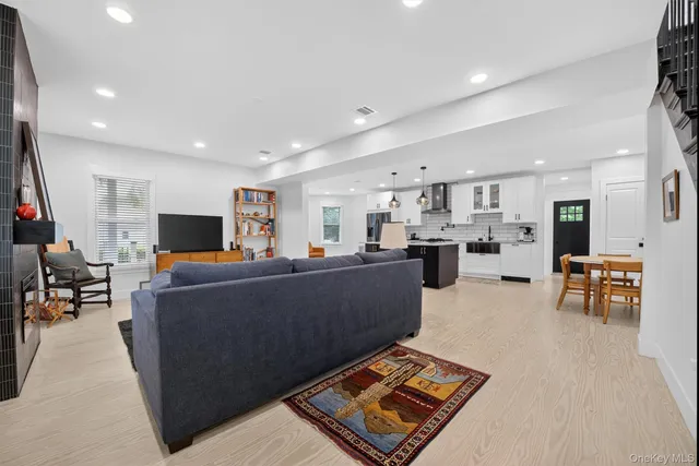 a living room with furniture and a dining table with kitchen view