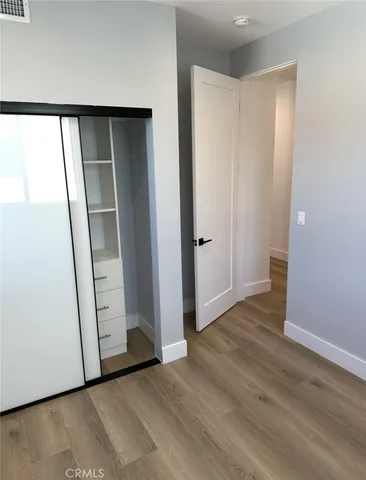 an empty room with wooden floor and entrance