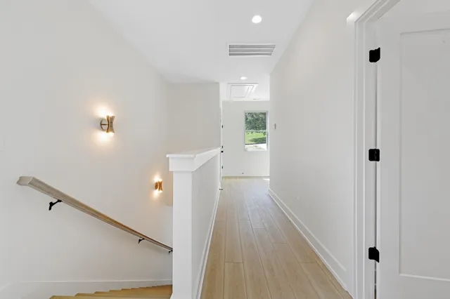 a view of a hallway with wooden floor and staircase