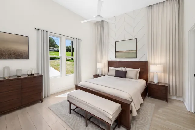 a bedroom with a bed and a flat tv screen on dresser