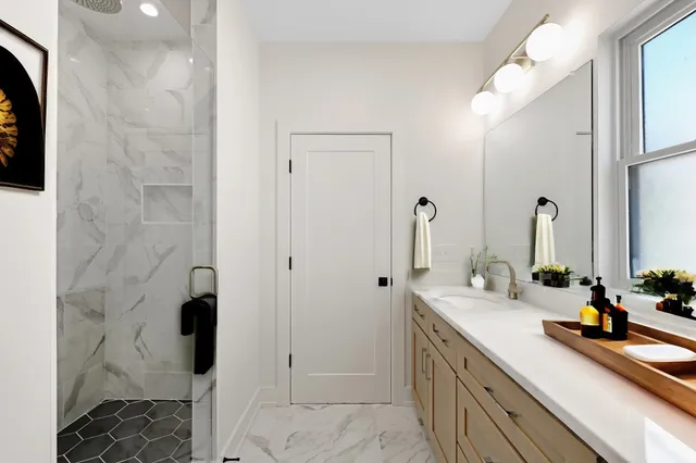 a spacious bathroom with a double vanity sink a mirror and shower