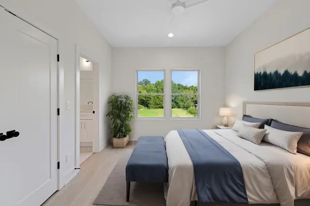 a bedroom with a large bed and a potted plant