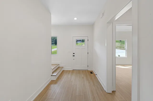 a view of a room with wooden floor and a hallway