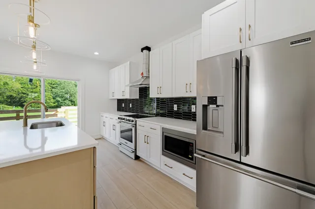 a kitchen with stainless steel appliances a refrigerator sink and microwave