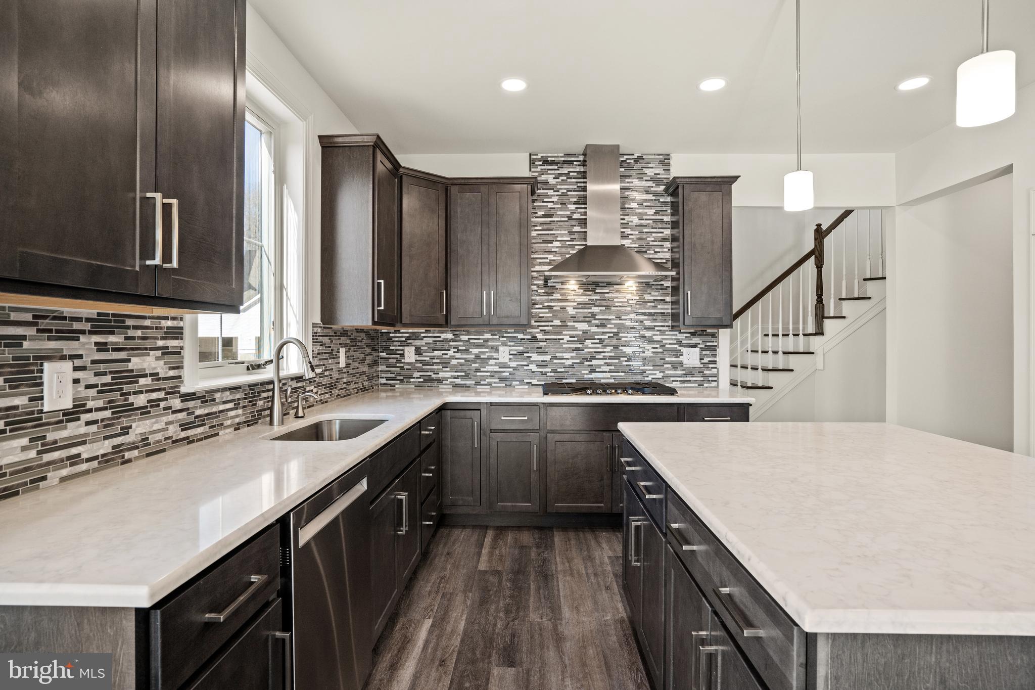a kitchen with stainless steel appliances kitchen island granite countertop a sink stove and cabinets
