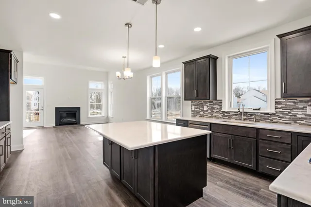 a kitchen with stainless steel appliances kitchen island granite countertop a refrigerator and a stove top oven