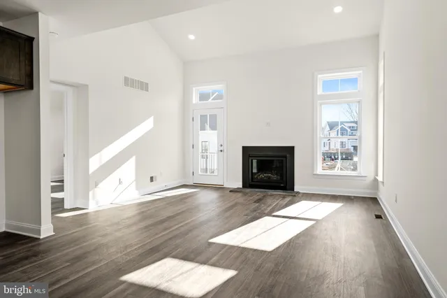 a view of an empty room with exposed radiator and a fireplace