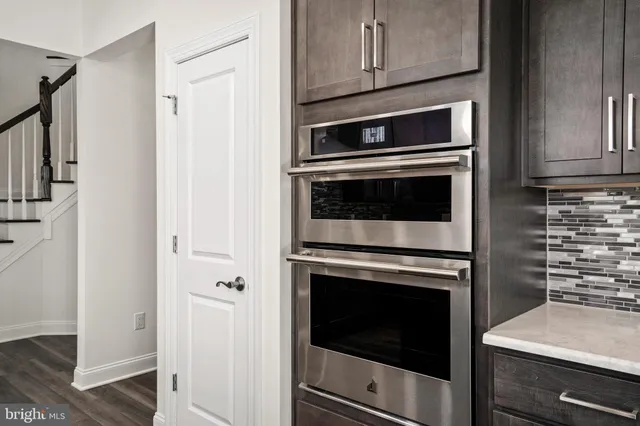 a large kitchen with kitchen island a island a sink a stove and wooden floor