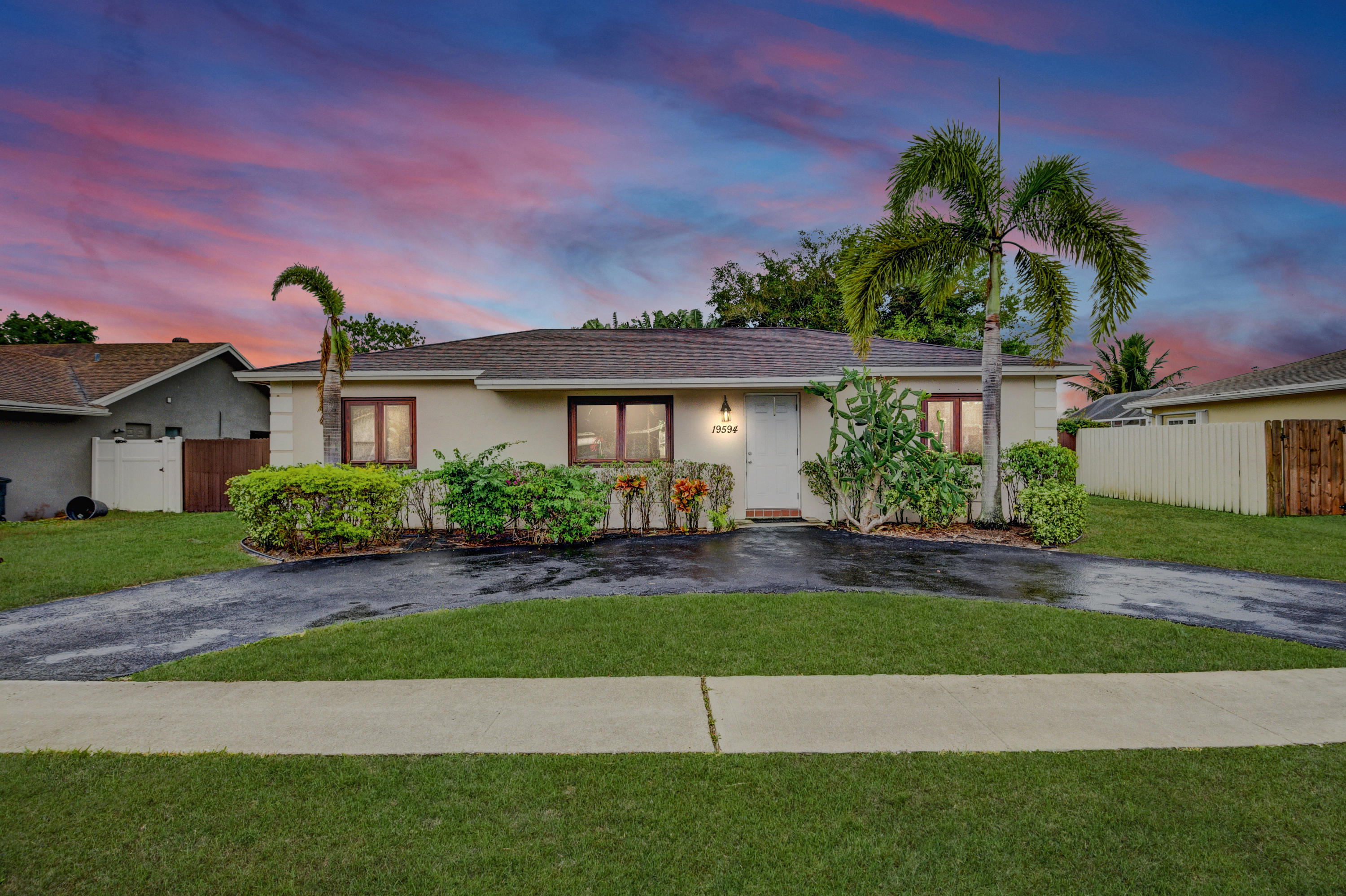 19594 Liberty Road Boca Raton, FL 33434 - Photo 1 of 53 a front view of a house with a yard and potted plants