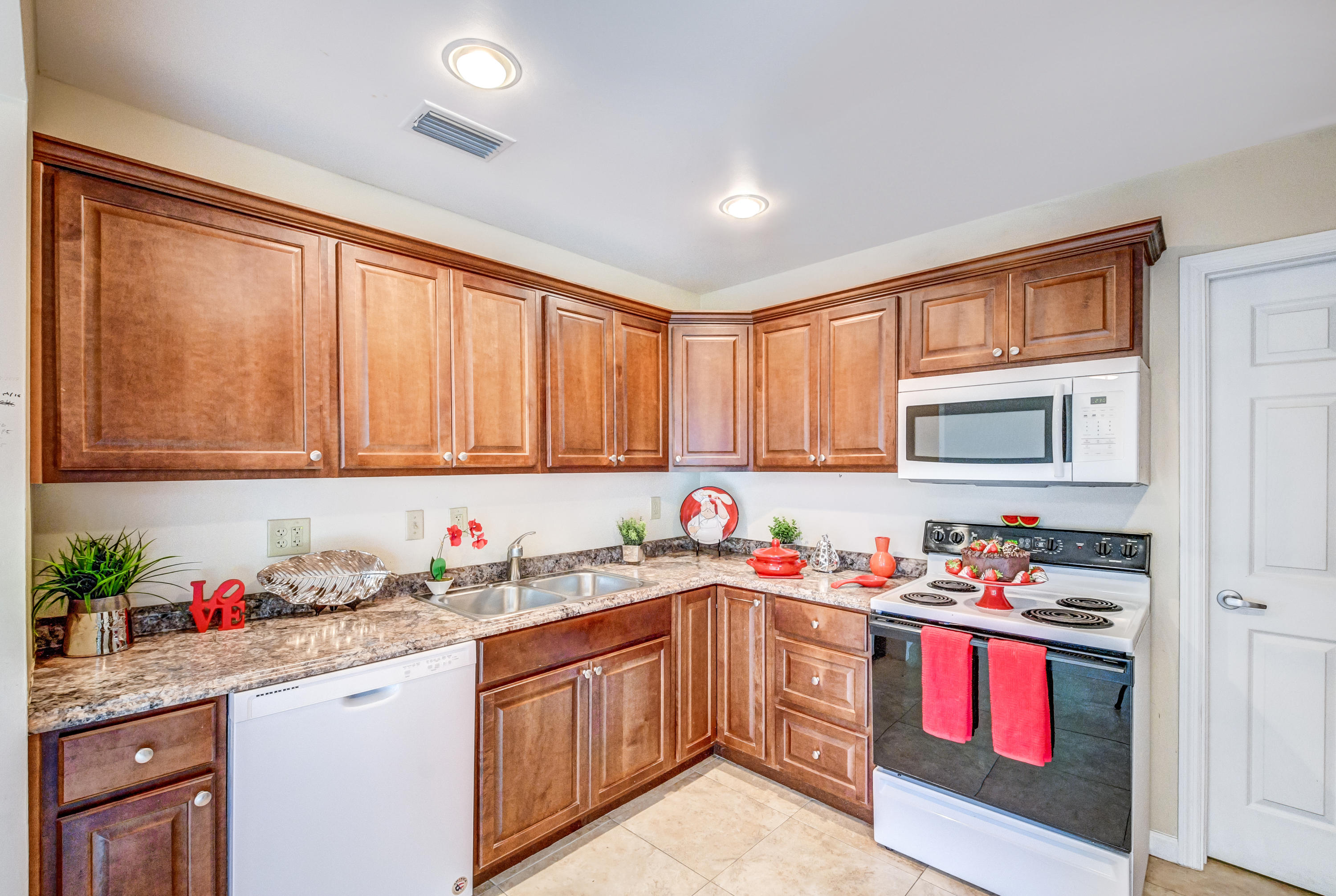 19594 Liberty Road Boca Raton, FL 33434 - Photo 18 of 53 a kitchen with stainless steel appliances granite countertop a sink window and cabinets
