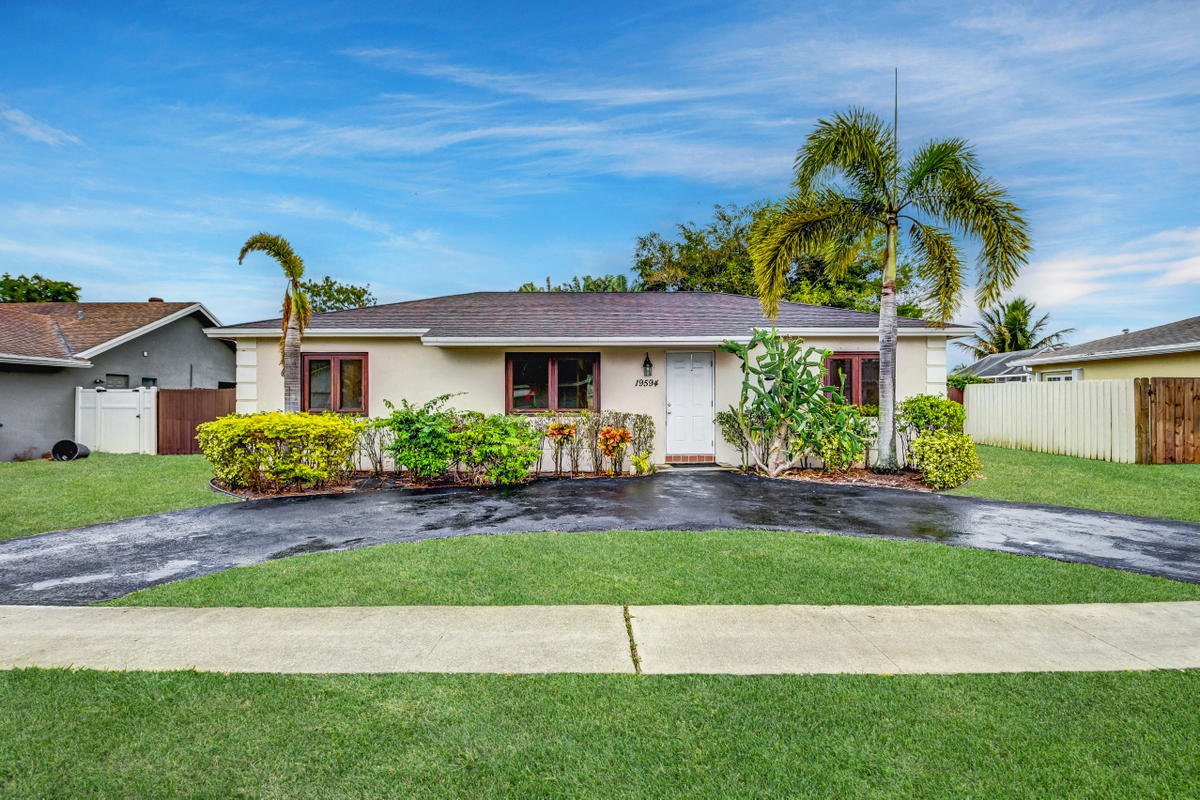 19594 Liberty Road Boca Raton, FL 33434 - Photo 2 of 53 a front view of a house with a yard and garage