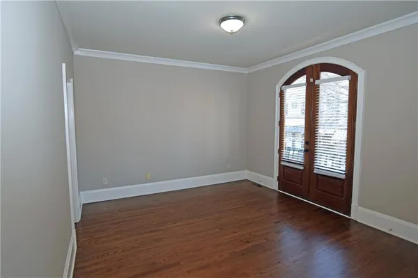 an empty room with wooden floor and window