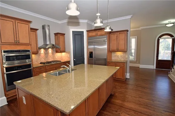 a kitchen with stainless steel appliances granite countertop a sink refrigerator and cabinets