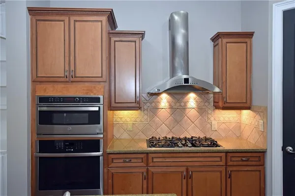 a kitchen with granite countertop a stove and a refrigerator