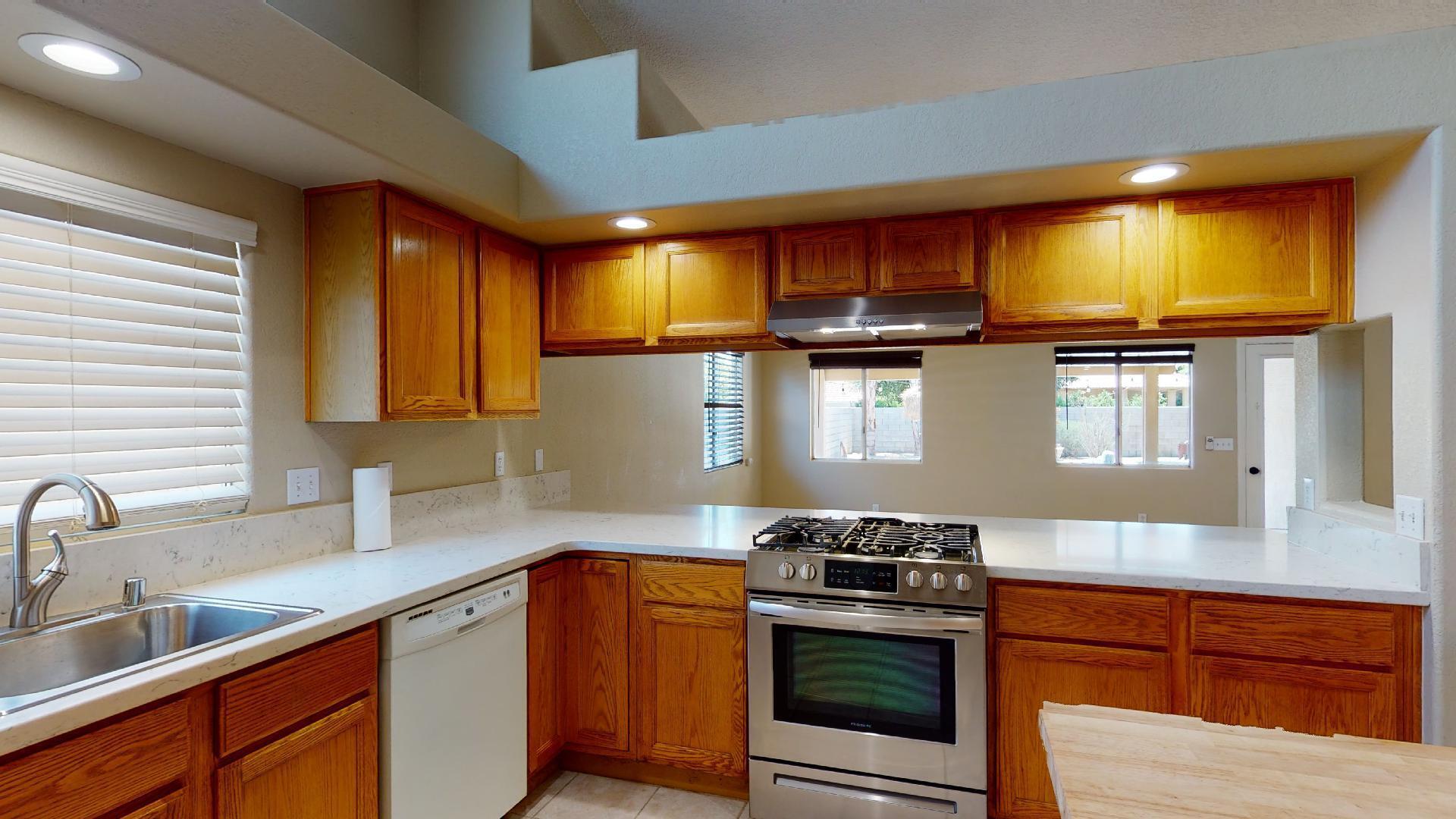 68373 Durango Road Cathedral City, CA 92234 - Photo 18 of 44 a kitchen with stainless steel appliances granite countertop a sink a stove and a microwave