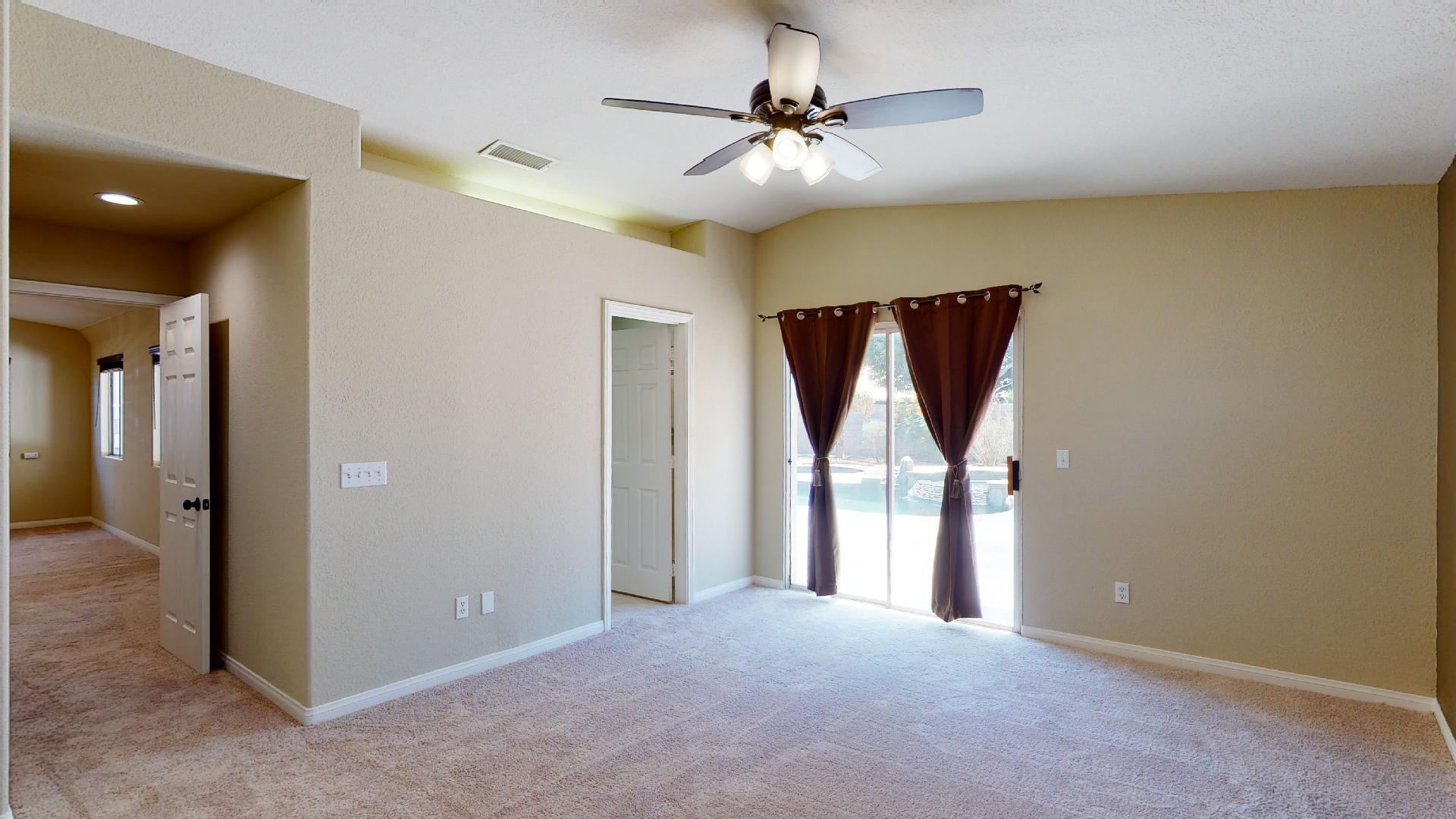 68373 Durango Road Cathedral City, CA 92234 - Photo 27 of 44 an empty room with windows and a chandelier fan