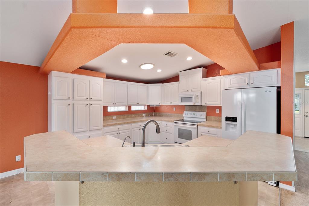 7863 Southwest 6th Place Ocala, FL 34474 - Photo 12 of 60 a kitchen with kitchen island a sink a stove and refrigerator