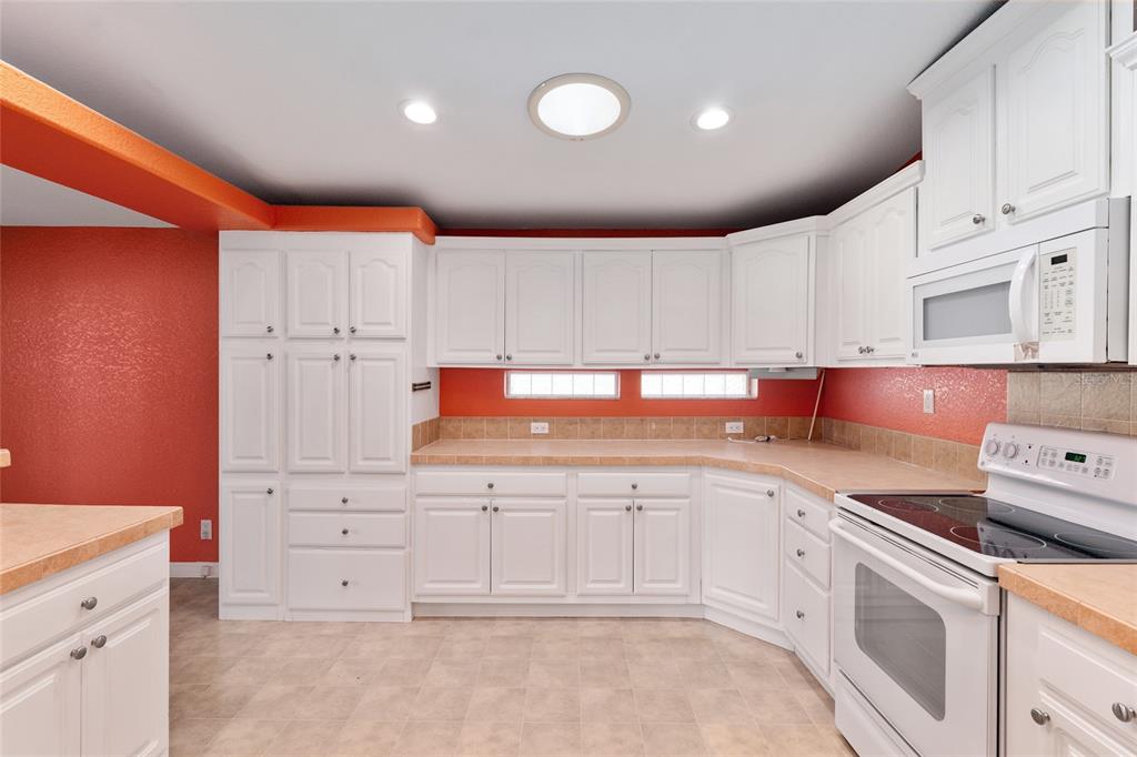 7863 Southwest 6th Place Ocala, FL 34474 - Photo 13 of 60 a kitchen that has a lot of cabinets in it and white appliances