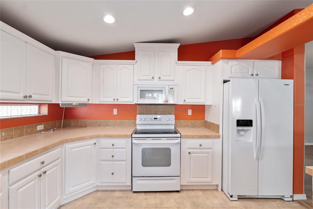 7863 Southwest 6th Place Ocala, FL 34474 - Photo 14 of 60 a kitchen with white cabinets and white appliances