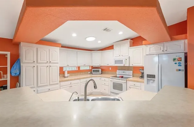 a kitchen with stainless steel appliances granite countertop a refrigerator and a sink