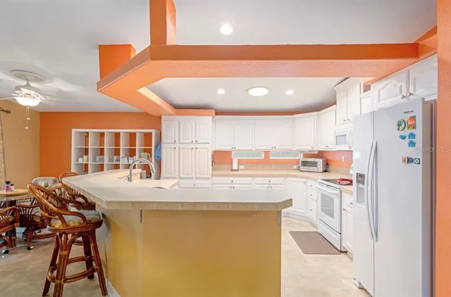 a kitchen with stainless steel appliances granite countertop a sink and a refrigerator