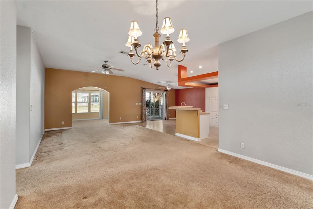 7863 Southwest 6th Place Ocala, FL 34474 - Photo 23 of 60 a view of a livingroom with a chandelier fan and kitchen view