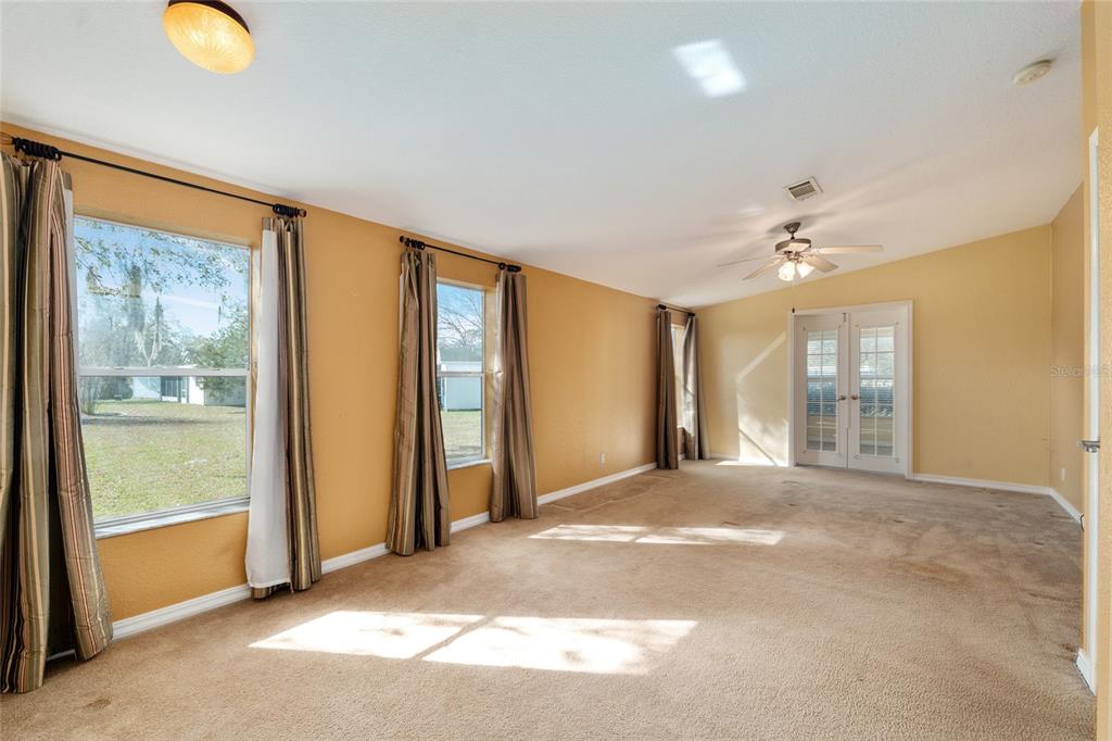 7863 Southwest 6th Place Ocala, FL 34474 - Photo 32 of 60 a view of a big room with windows and chandelier fan