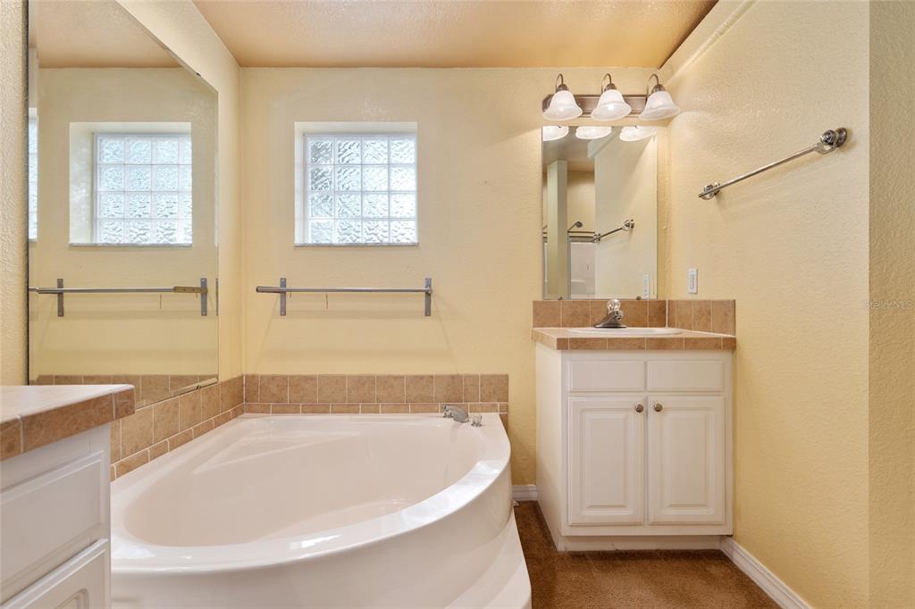 7863 Southwest 6th Place Ocala, FL 34474 - Photo 36 of 60 a bathroom with a tub a sink and a mirror