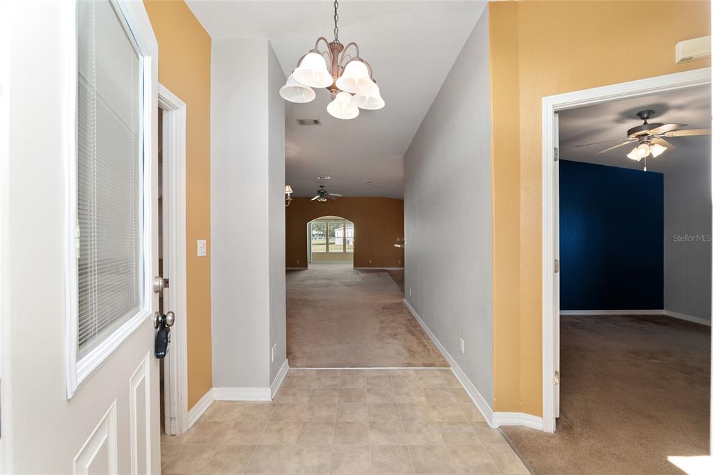7863 Southwest 6th Place Ocala, FL 34474 - Photo 4 of 60 a view of a hallway with wooden floor and chandelier