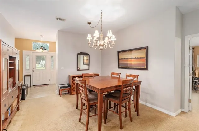 a dining room with furniture a chandelier and window