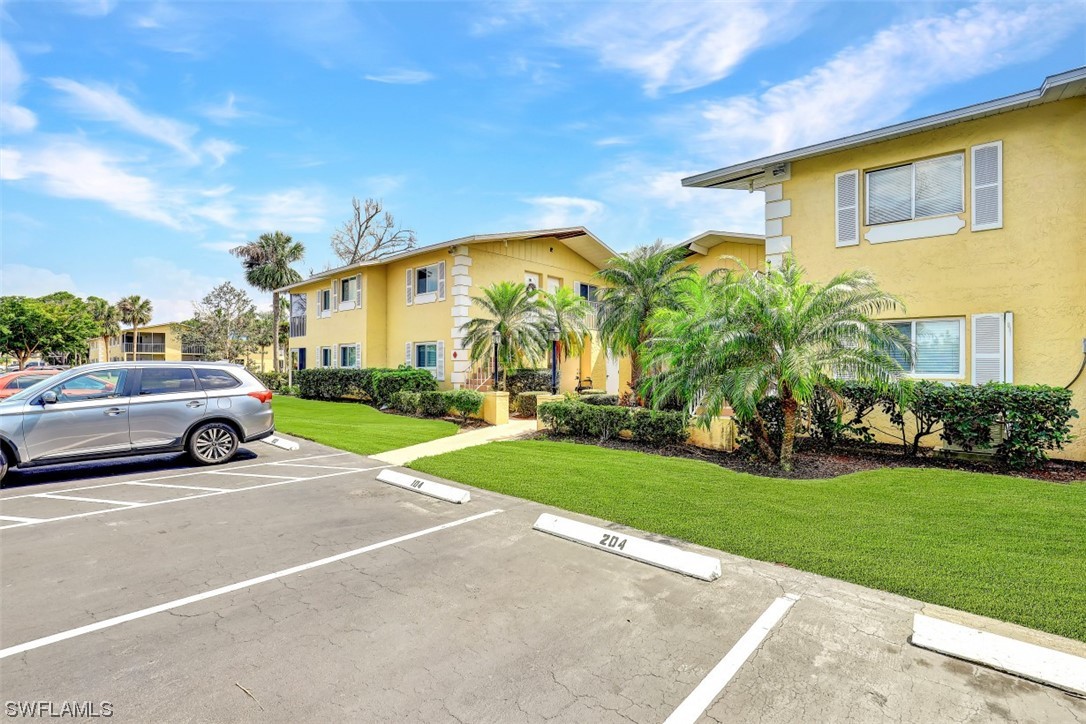 8109 Country Road, Unit 103 Fort Myers, FL 33919 - Photo 19 of 19 a view of a car parked in front of a house with a big yard