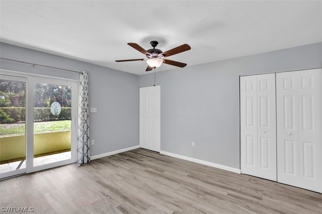 8109 Country Road, Unit 103 Fort Myers, FL 33919 - Photo 7 of 19 an empty room with wooden floor and a floor to ceiling window