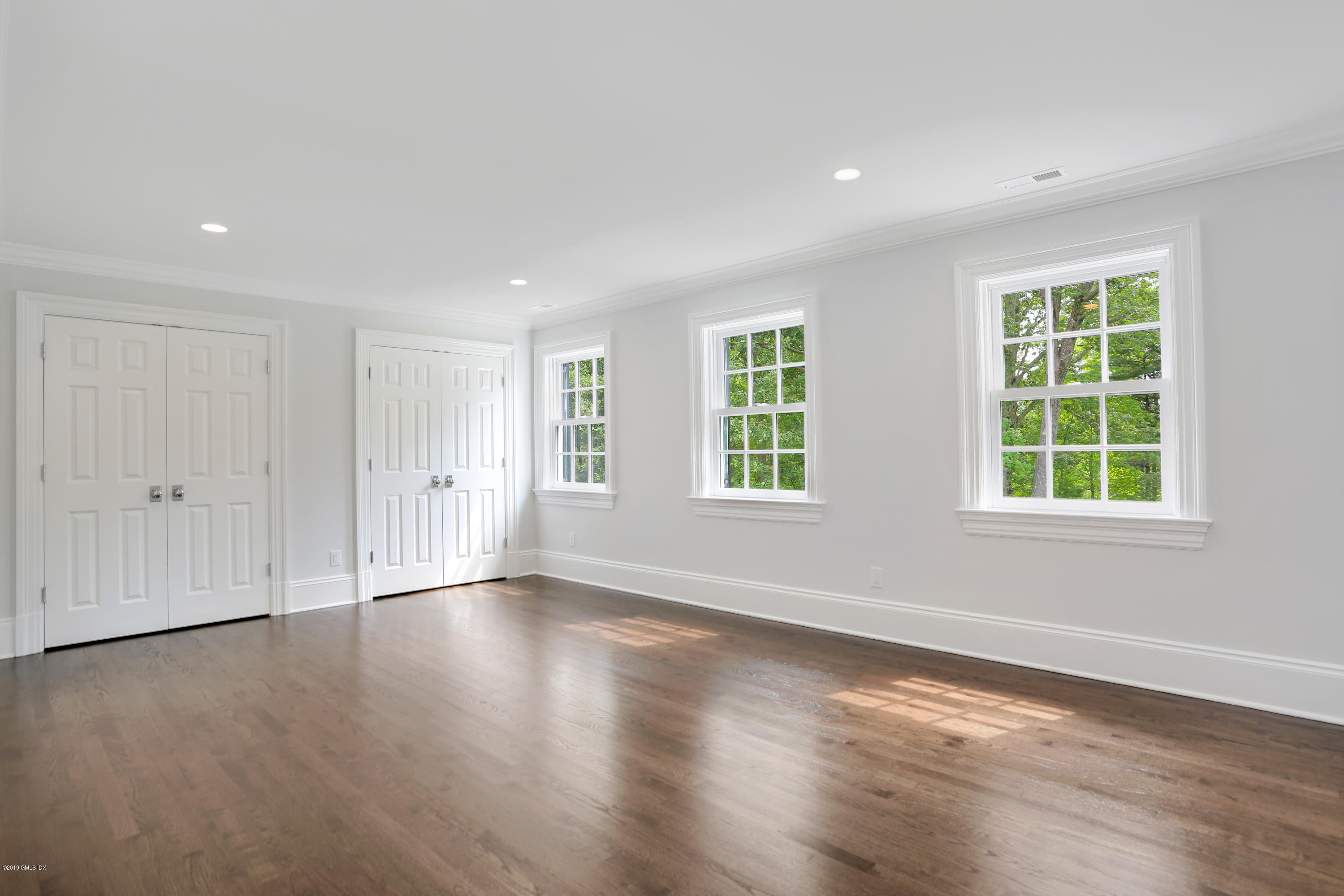 101 Dingletown Road Greenwich, CT 06830 - Photo 30 of 40 an empty room with wooden floor and windows