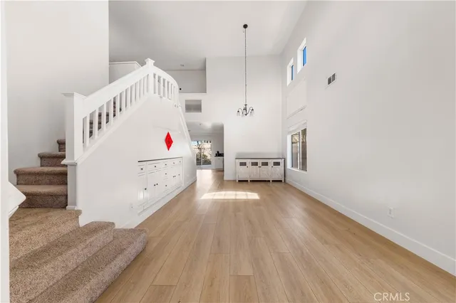 a view of a hallway with stairs and wooden floor