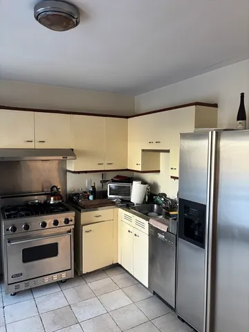 a kitchen with stainless steel appliances a stove a sink and a refrigerator