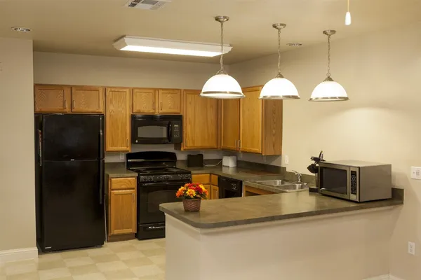 a kitchen with stainless steel appliances granite countertop a sink and a refrigerator