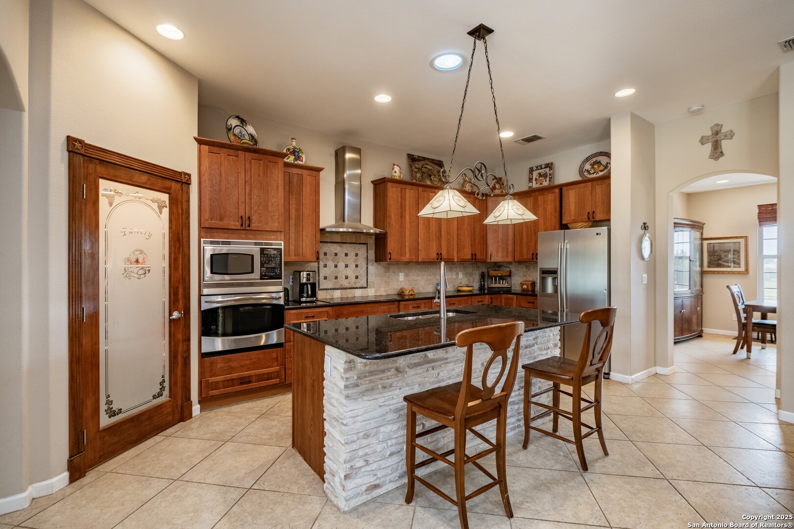 233 N Fork Bandera, TX 78003 - Photo 11 of 71 a kitchen with stainless steel appliances kitchen island granite countertop a refrigerator and chairs
