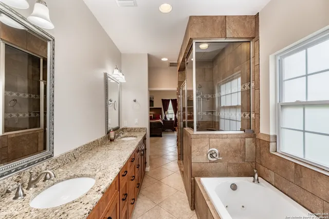 a bathroom with a granite countertop sink a toilet a mirror and shower