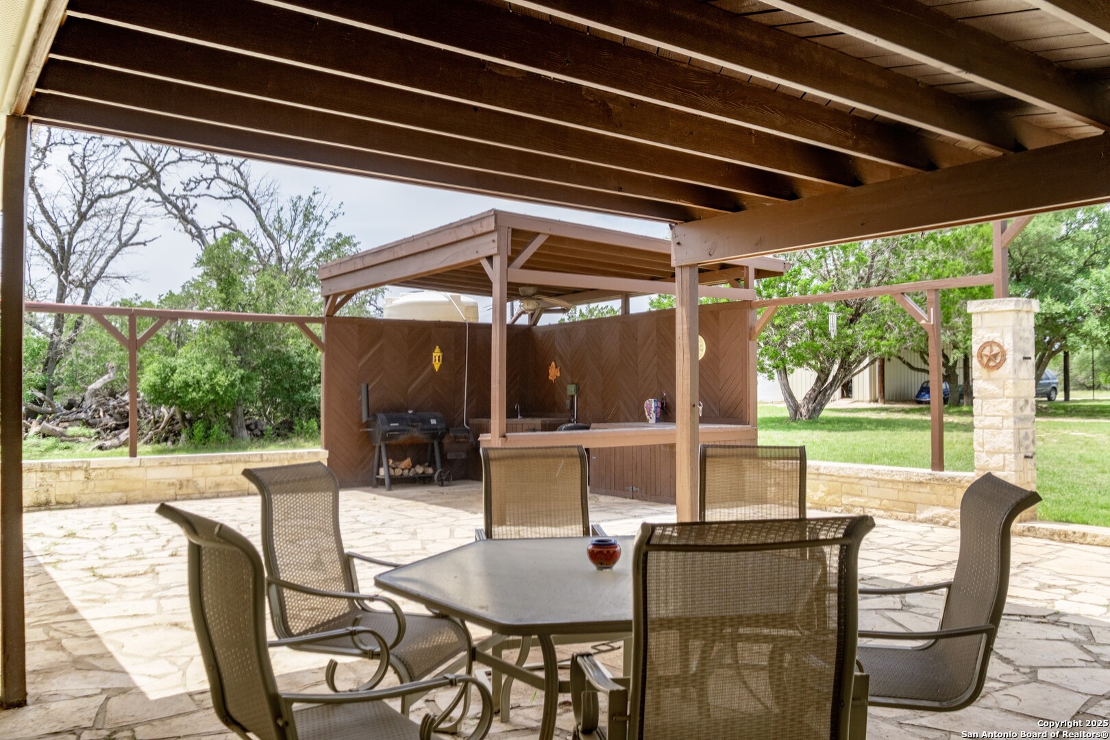 233 N Fork Bandera, TX 78003 - Photo 30 of 71 a view of a patio with a table chairs and a backyard