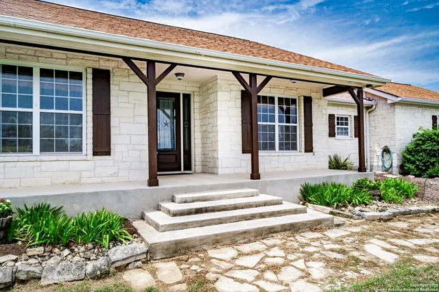a living room with furniture a fireplace a flat screen tv and a large window