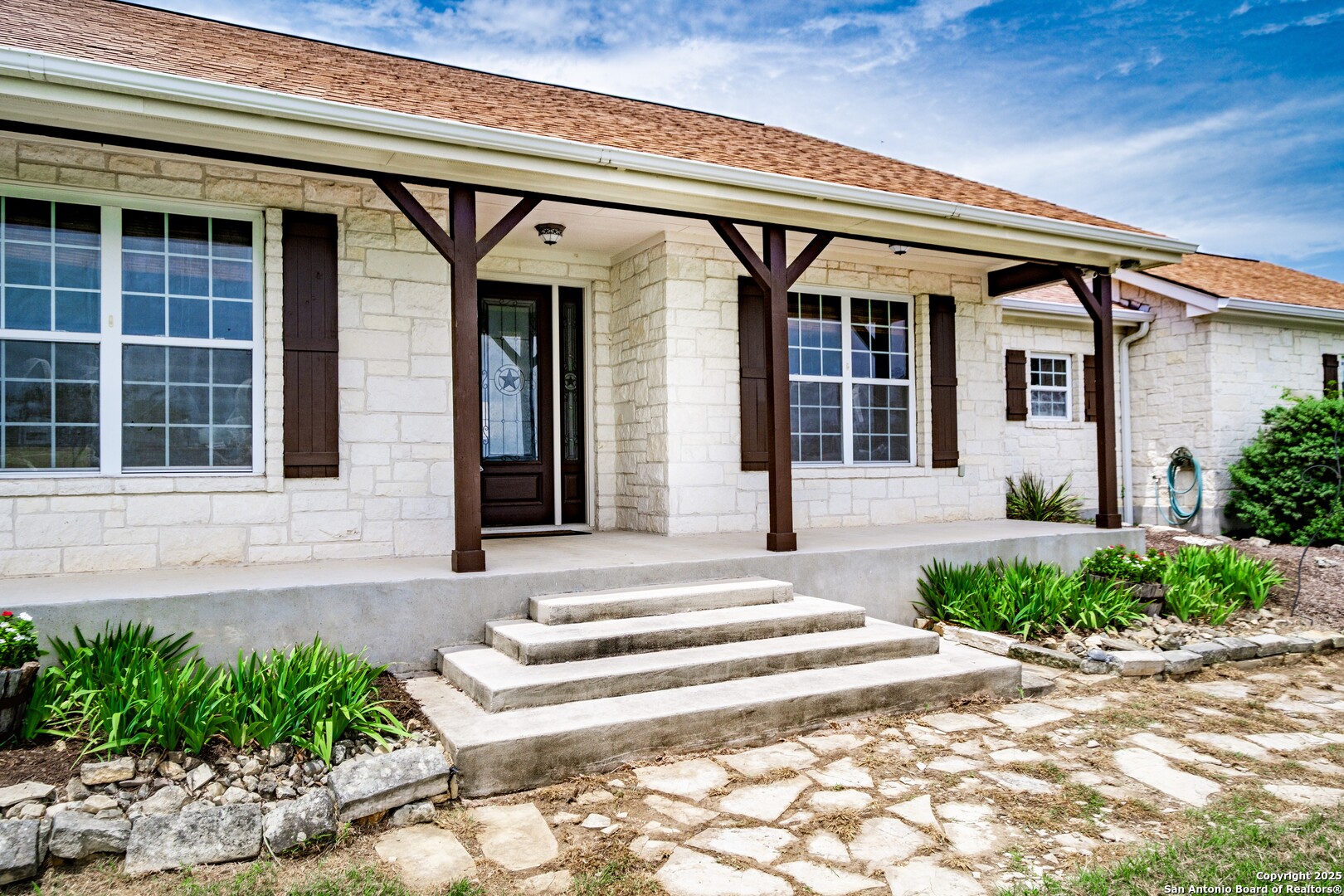 233 N Fork Bandera, TX 78003 - Photo 3 of 71 a front view of a house with a garden