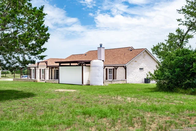 a kitchen with stainless steel appliances a dining table chairs and wooden floor