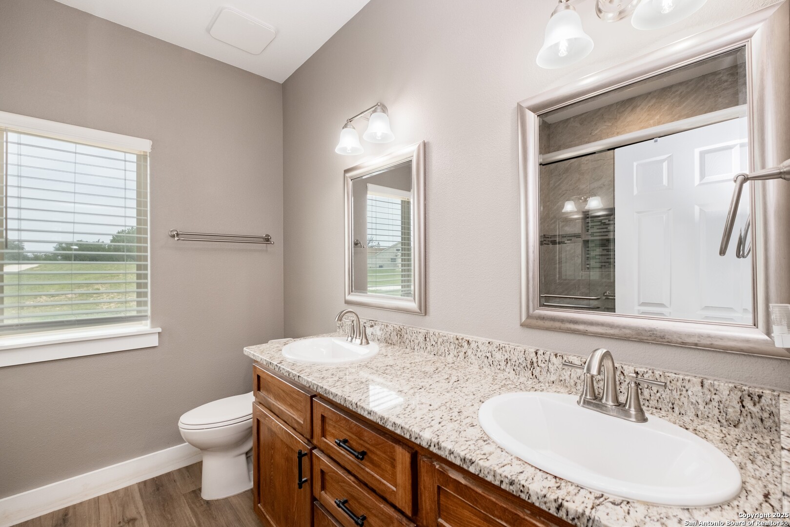 233 N Fork Bandera, TX 78003 - Photo 52 of 71 a bathroom with a granite countertop sink a toilet and a mirror