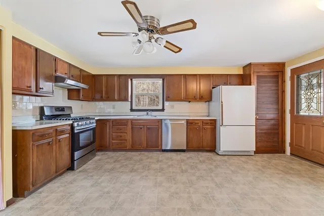 a kitchen with stainless steel appliances a refrigerator a sink a stove a microwave and island