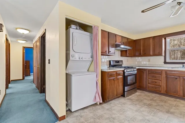 a kitchen with granite countertop a sink stove and refrigerator