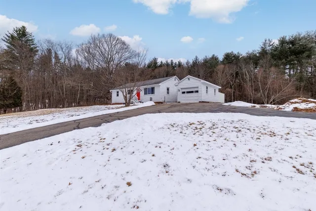 a view of a dry yard covered with snow in front of house