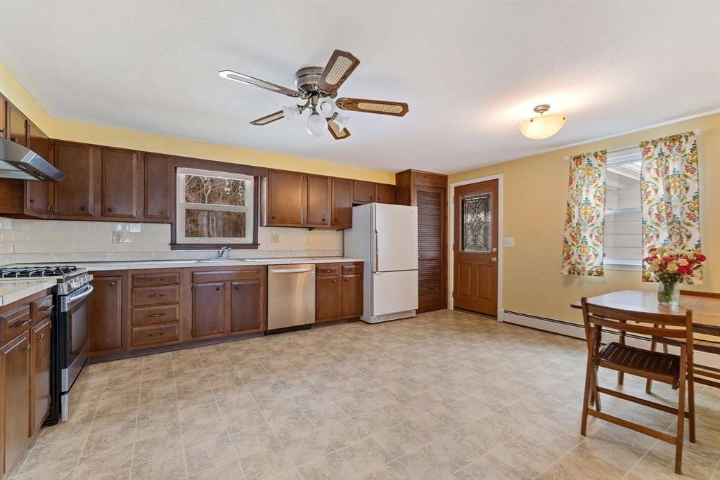 8 Cider Mill Road North Brookfield, MA 01535 - Photo 6 of 30 a kitchen with stainless steel appliances a stove a sink dishwasher a refrigerator with white cabinets and wooden floor