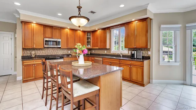 a kitchen with stainless steel appliances a stove a sink a dining table and chairs